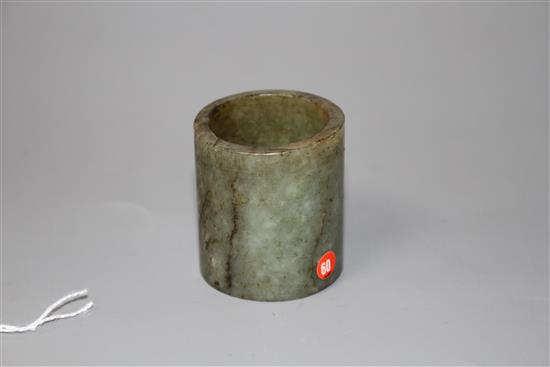 A Chinese celadon and brown jade cylinder, probably archaic, H. 4.6cm